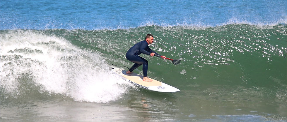 Coach Jonathan surfing a wave