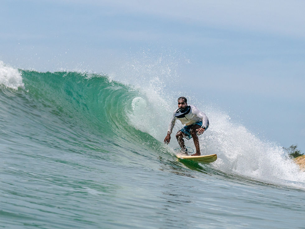 Man surfing a wave in Arugam Bay