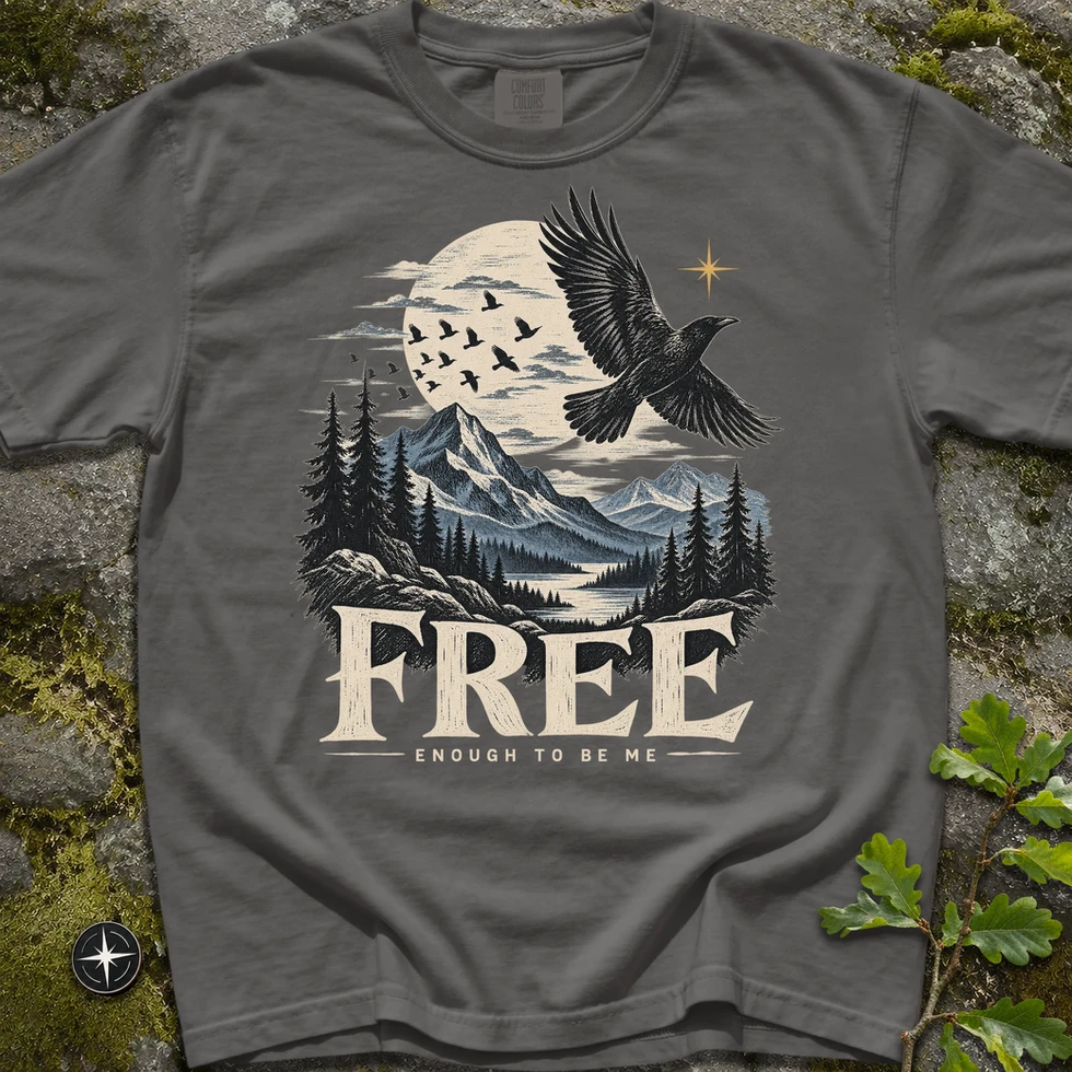 My Real North Free Raven T-Shirt i mörkgrått, tryck med flygande korp över bergslandskap och texten "Free, enough to be me"