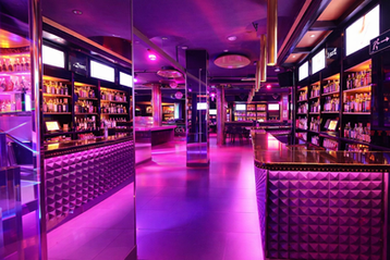 Modernes Interieur des Sala Gold in Málaga, Spanien: Violettes Licht, Spiegel und ein eleganter Barbereich. Teil der South Tours Málaga Pub Crawl.