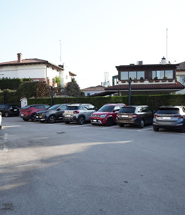 Spacious private parking of Hotel Maritan in Padova with several cars parked.