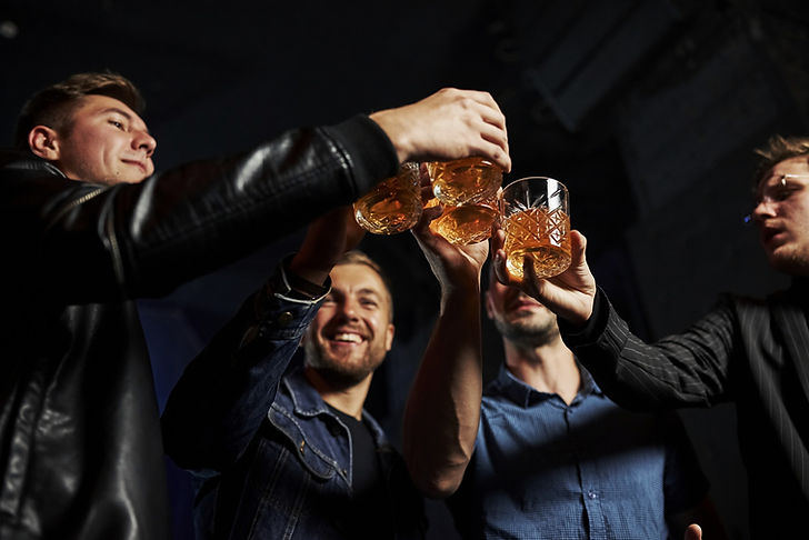 Group of friends toasting with cocktails in a nightclub during the Malaga Pub Crawl in Malaga, Spain