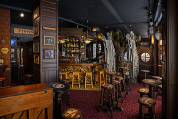 Interno della Sala Premiere di Malaga, Spagna: un pub elegante con arredi classici, un bancone decorato e un'atmosfera accogliente.