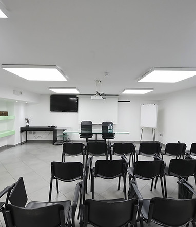 Ambiance de réunion lumineuse de l'Hotel Maritan Padoue avec table des conférenciers et tableau à feuilles mobiles.