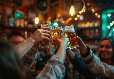 Group of friends toasting with beers during the Malaga Pub Crawl in the lively nightlife of Malaga, Spain