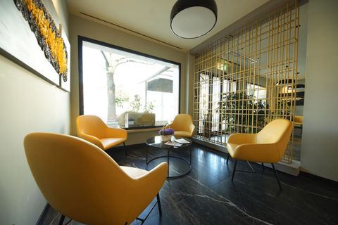 Area lounge con poltrone moderne e tavolino vicino alla finestra all’Hotel Maritan Padova