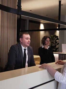 Personnel de la réception qui accueille les clients au comptoir de l'Hotel Maritan Padoue