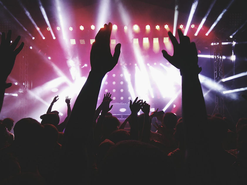 People dancing with raised hands inside a Málaga club on a Pub Crawl experience