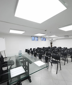 Salle de conférence de l'Hotel Maritan Padova équipée d'un écran et d'un projecteur pour des présentations professionnelles.