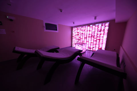 Sala relax con lettini e parete di sale illuminata rosa nella SPA dell’Hotel Maritan Padova