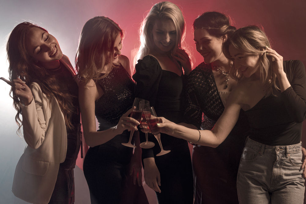 Group of girls toasting with cocktails in a nightclub during the Pubcrawl Malaga experience organised in Malaga, Spain.
