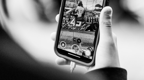 Child Looking At A Racecar On His Phone