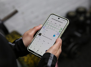 A white person is holding a smart phone with a workout shown on an app
