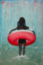 Girl in black and white walks into the blue greenish sea with a large pink swimming belt