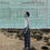 Thumbnail: Man in white shirt stands alone in desert grassland and desert road with light aqua  background
