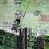 Thumbnail: Street art, pop art, collage artwork in greens about two boys on a swing in front of large dark green builings