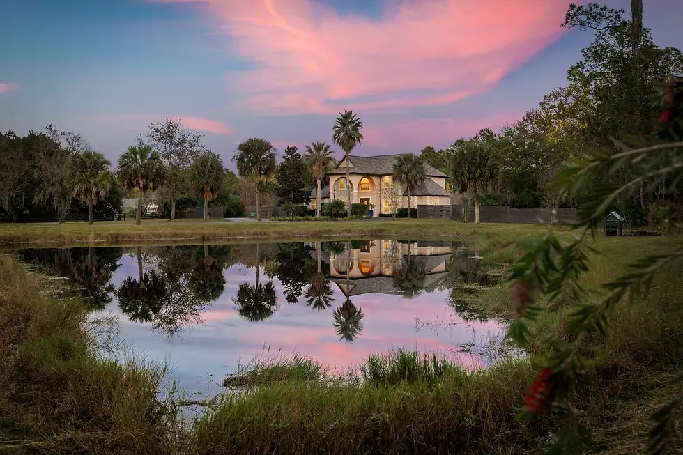 Waterfront estate with stone stucco architecture reflected in pond at golden hour in St Augustine