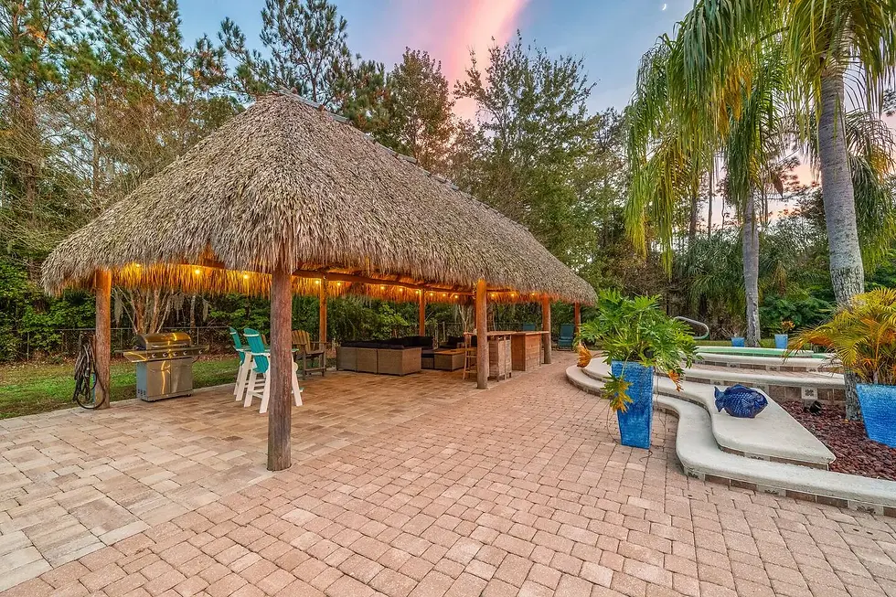 Luxury tiki gazebo and tropical patio with palm trees at sunset in St Augustine vacation rental