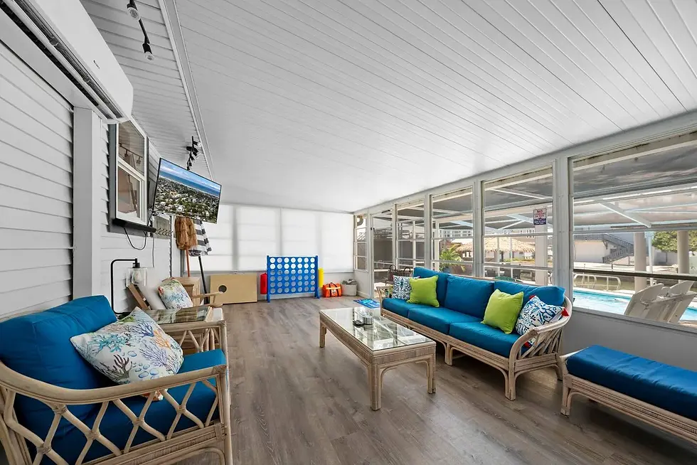 Bright sunroom with blue cushioned seating overlooking private pool at St Augustine FL house rental with canal access