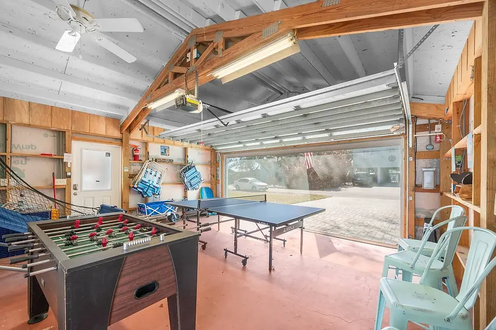 Converted garage recreation space with foosball and ping pong tables, wooden beams, and LED lighting at Salty Sunrise