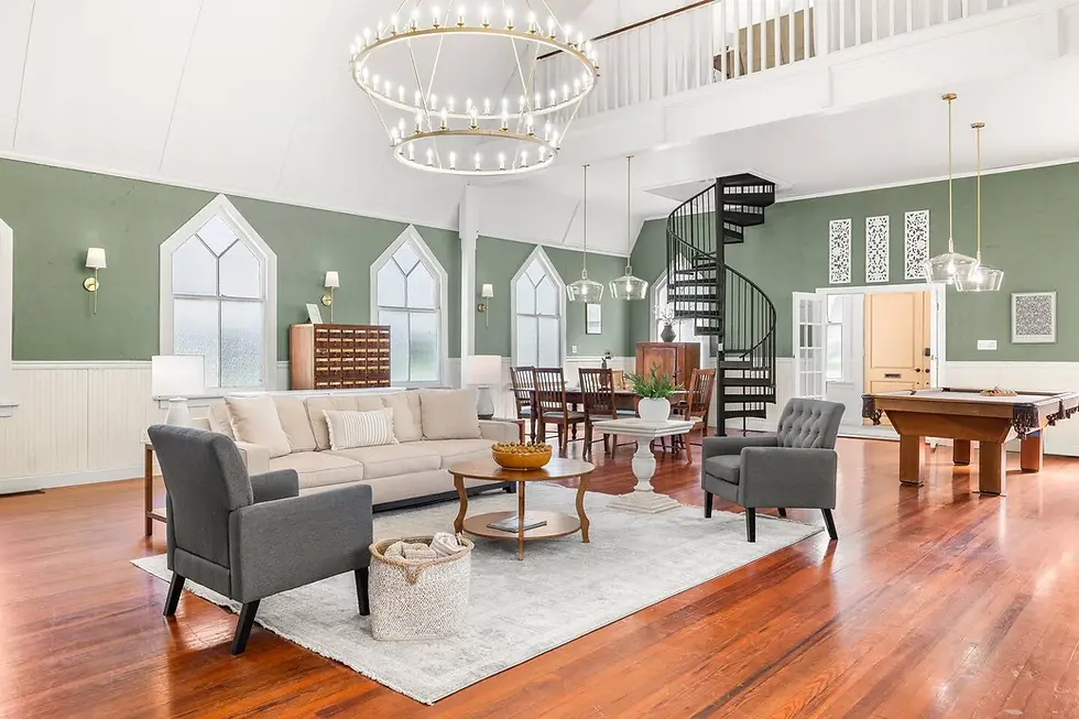 Luxury open-concept living room with sage green walls, high ceilings, and modern chandelier in St. Augustine vacation rental
