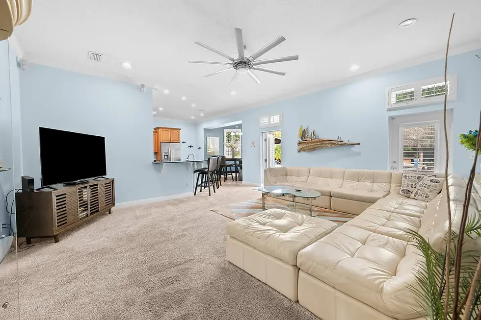 Bright open-concept living room with cream sectional and modern TV setup, ideal for seasonal demand forecasting in St.