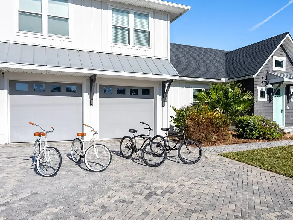 Modern beach house exterior with white facade, garage doors, and rental bikes in St. Augustine