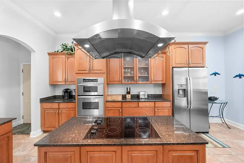 Modern kitchen with granite countertops, cherry cabinets, and stainless steel appliances in St. Augustine Florida