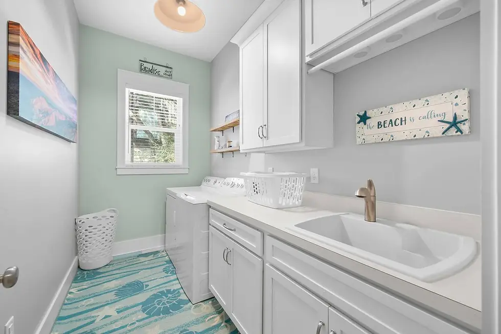 Bright coastal laundry room with white cabinetry, mint walls, and beach decor in St. Augustine beachfront condo