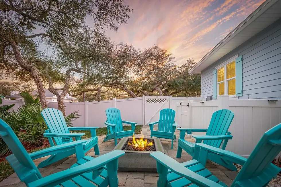 Turquoise Adirondack chairs around fire pit in coastal backyard rental in St. Augustine FL