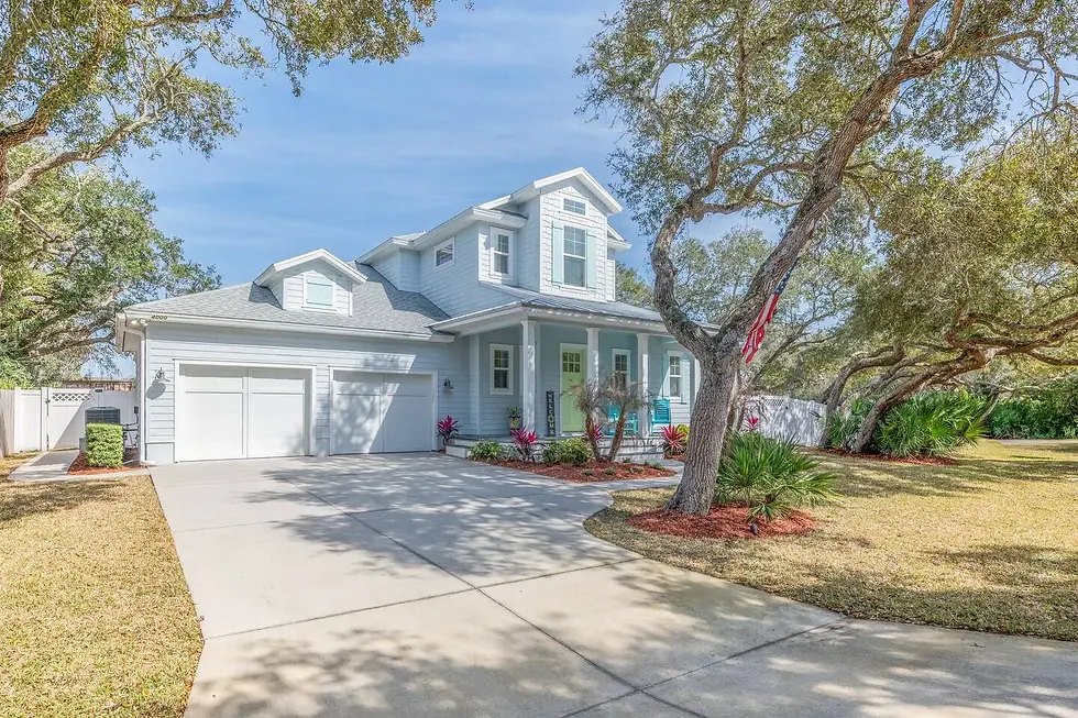 Beachside cottage exterior with white farmhouse style and mint accents for vacation rental booking in St. Augustine FL