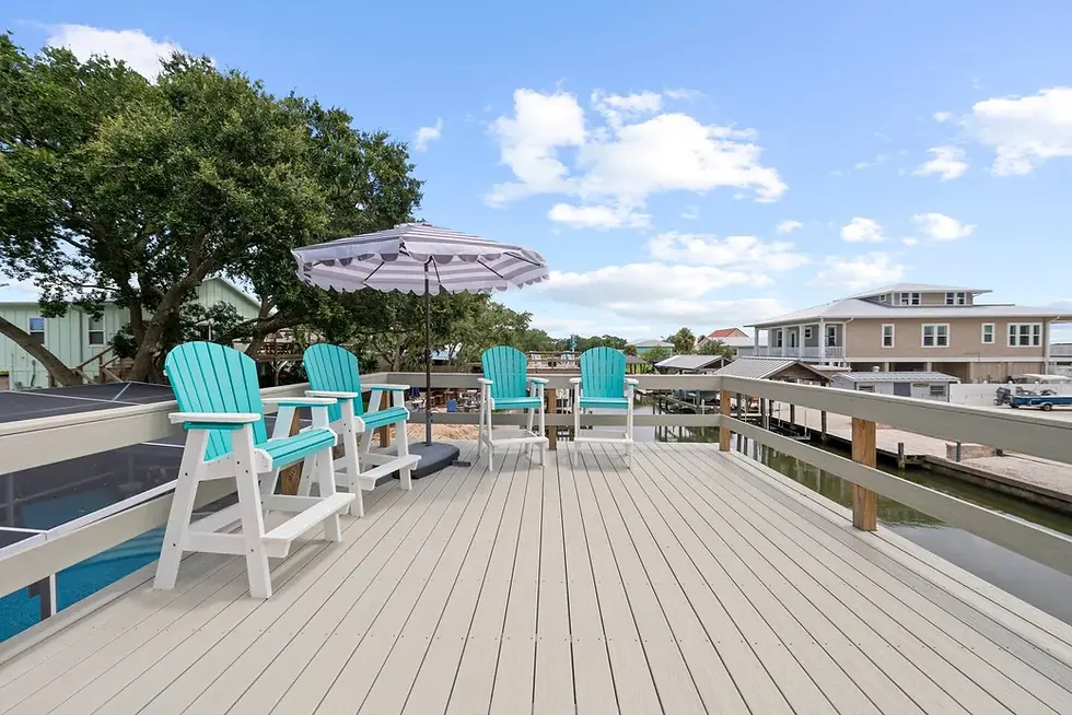 Waterfront deck at St. Augustine Airbnb with turquoise Adirondack chairs and canal view