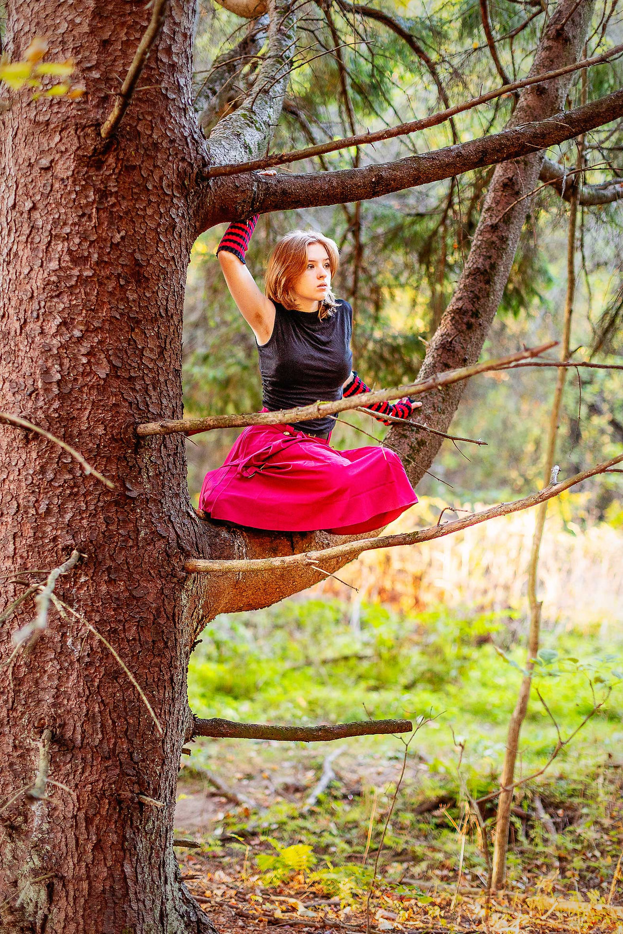 Senior girl high in a tree reading a book