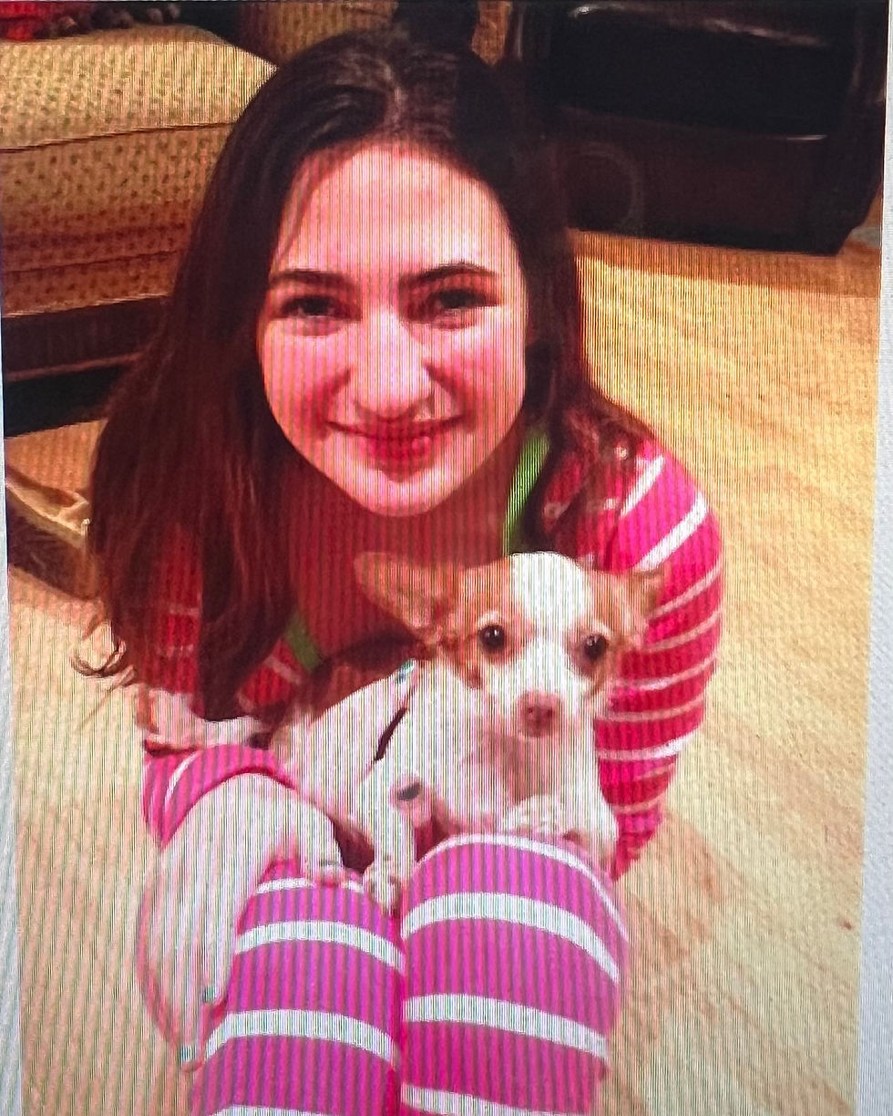 A teenage girl holding a chihuahua