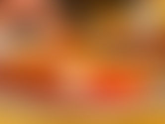 The Claremont St Annes Breakfast: Plate with bacon, eggs, beans, mushrooms, sausage, and tomato on a yellow tablecloth. A hand cuts with a knife and fork.