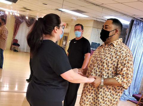 Instructor teaching social couple new steps in the American foxtrot at Bravo Dance Studio.