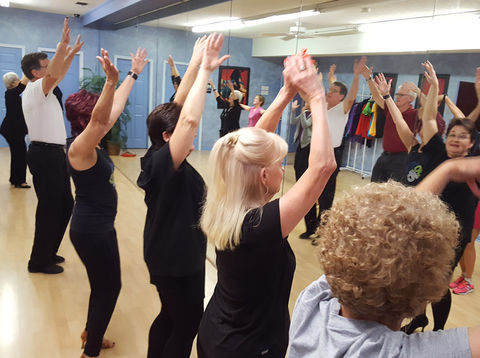 Group of dancers practicing line dance in Bravo Dance Studio’s small ballroom.