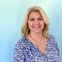 portrait of Maggie Salter smiling in blue floral shirt