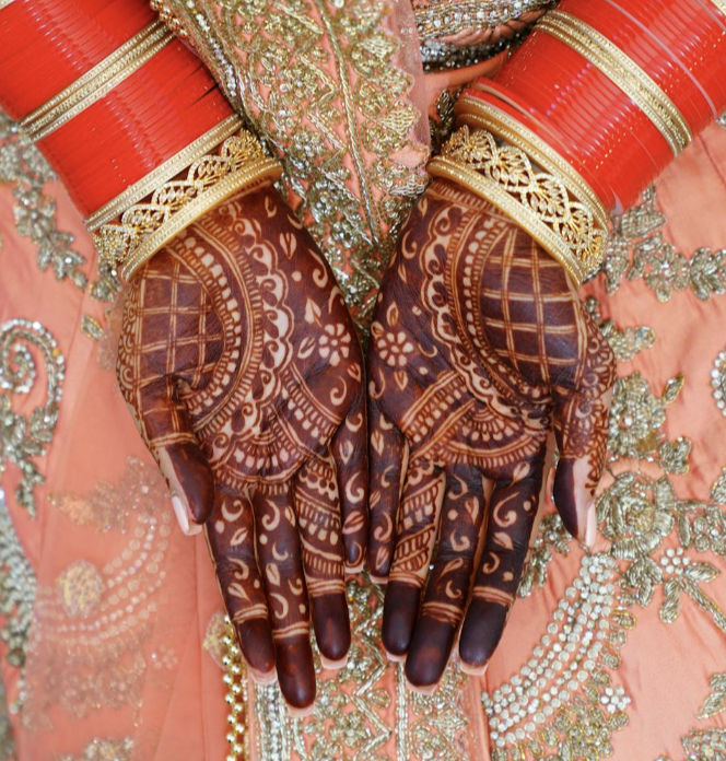 Front hand mehndi with deep reddish stain, grid and floral motifs, and symmetrical fingertip fills
