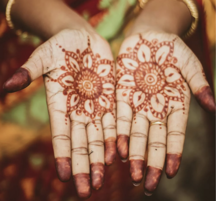 Front hand mehandi with circular mandala flowers in the center of each palm
