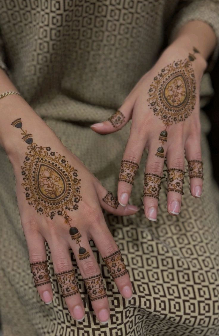 Back-hand mehndi with paisley centerpiece and fine floral detailing