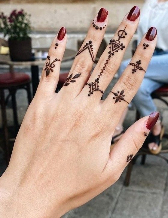 mehndi with geometric and tribal-style designs on each finger
