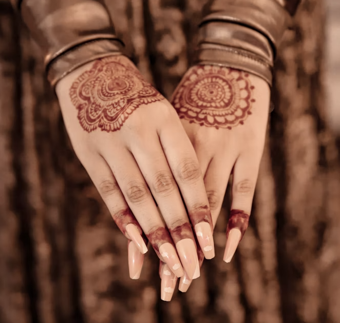 Back of both hands featuring bold mandala-style mehndi designs near the wrists