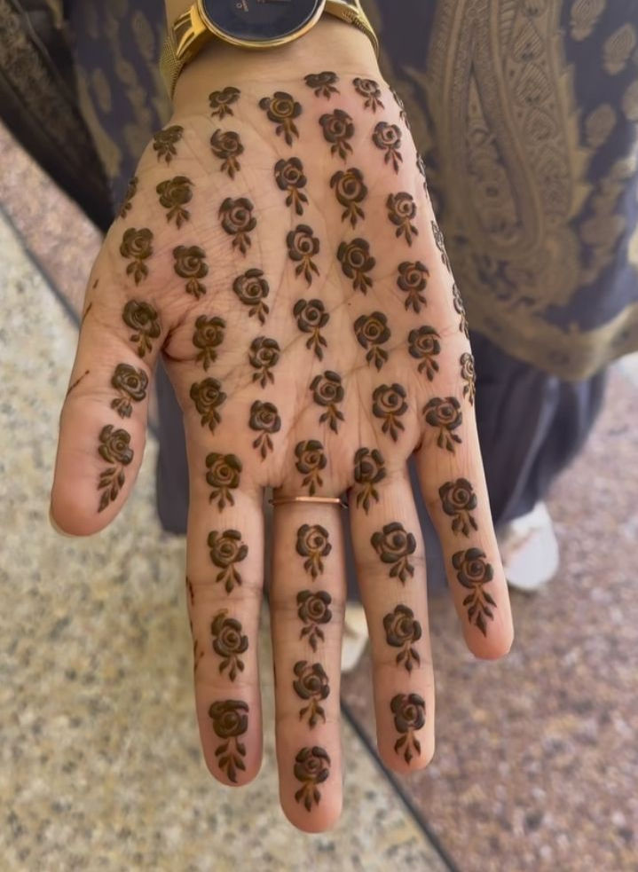 Front hand covered in small henna rose motifs arranged in neat rows