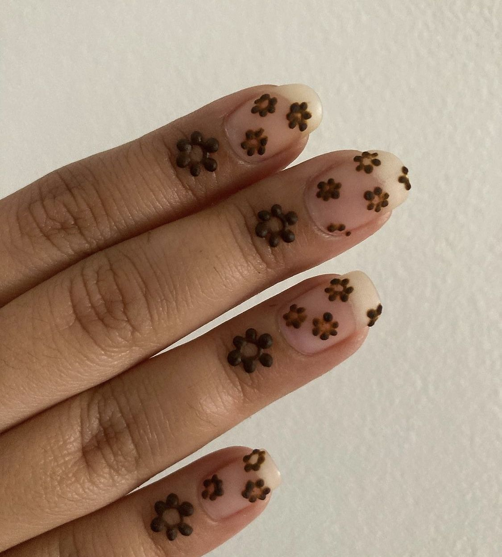 Minimalist mehndi flowers drawn on fingertips and nails