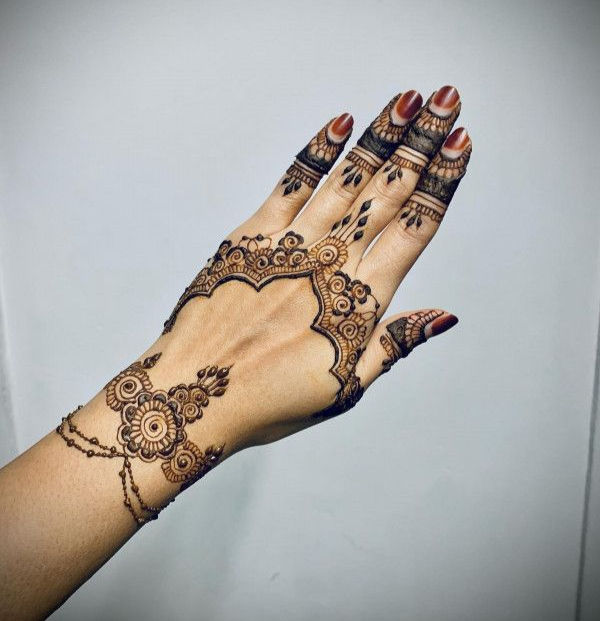 mehndi design with an arched floral frame, intricate dots, and lace-filled fingers
