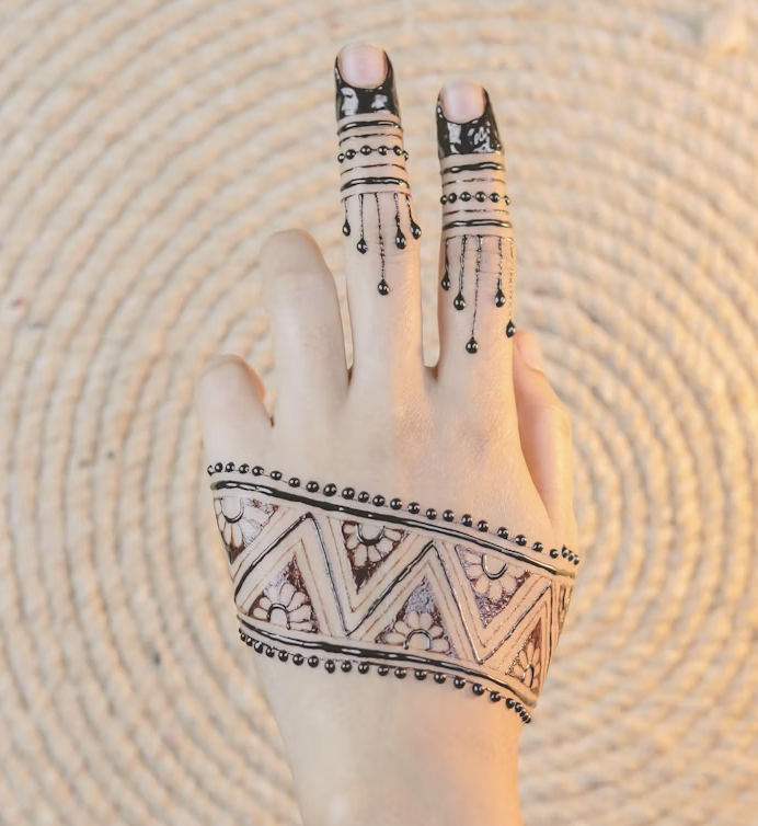 Minimal back hand henna pattern with a zigzag floral band across the hand