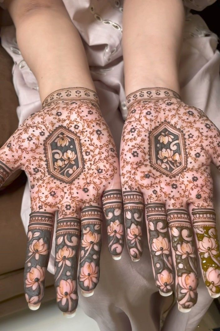 Bridal mehndi with pastel floral fingertips and hexagonal center details