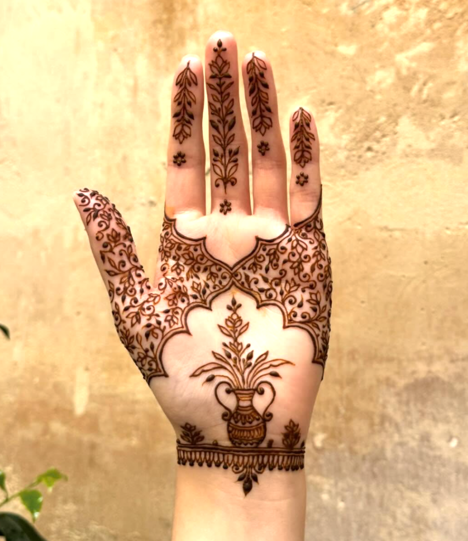 Front hand mehndi with a vase of flowers as the central motif