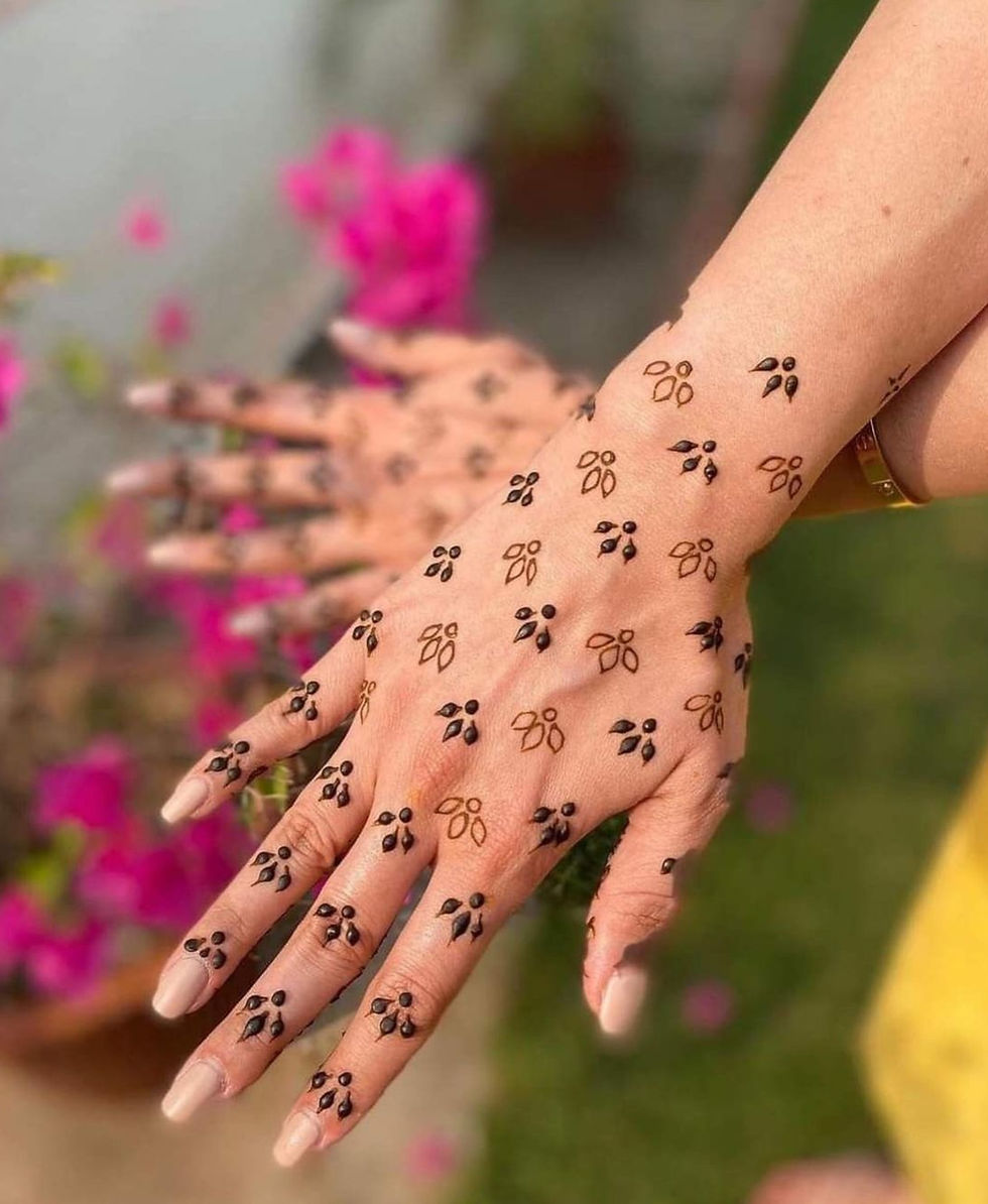 Back hand mehndi design featuring small leaf-like clusters